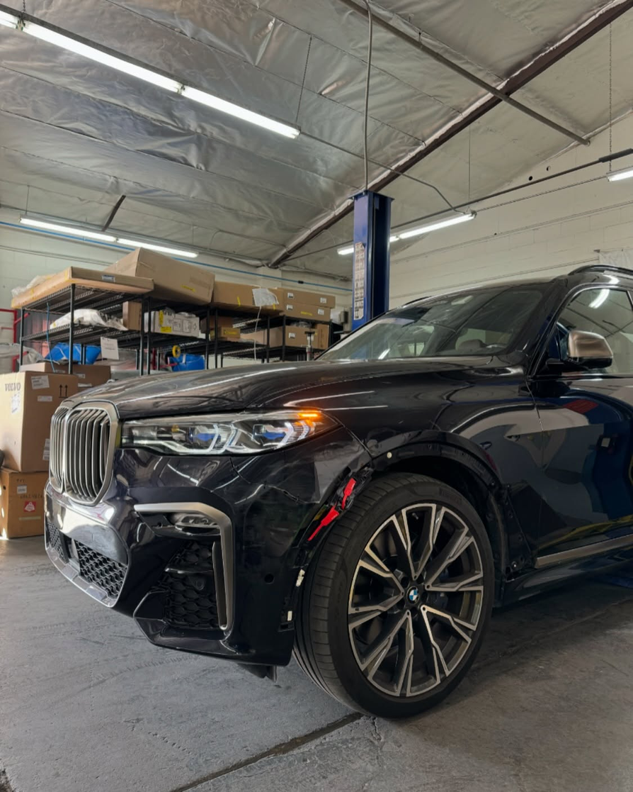 BMW X7 inside Supreme Collision Center auto body shop in Fullerton CA for collision repair work